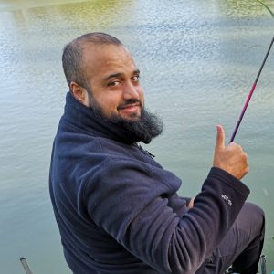 Asian man giving thumbs up after catching his first fish